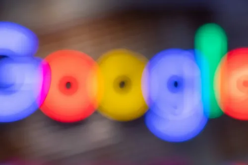 Blurry Google neon sign with letters spelled out in rainbow colors.